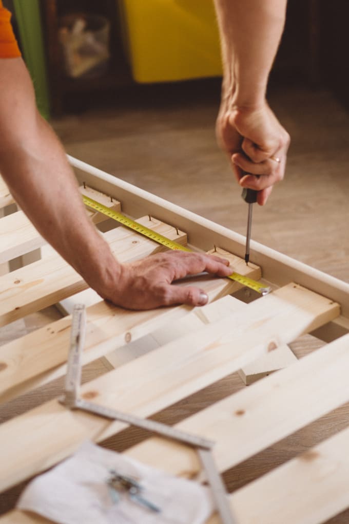 cropped-hands-man-measuring-wood-home